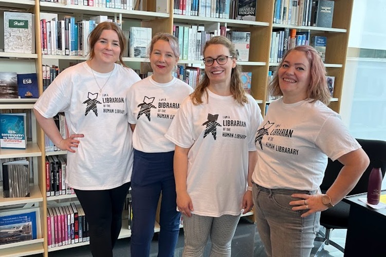 Four women in t-shirts marked 