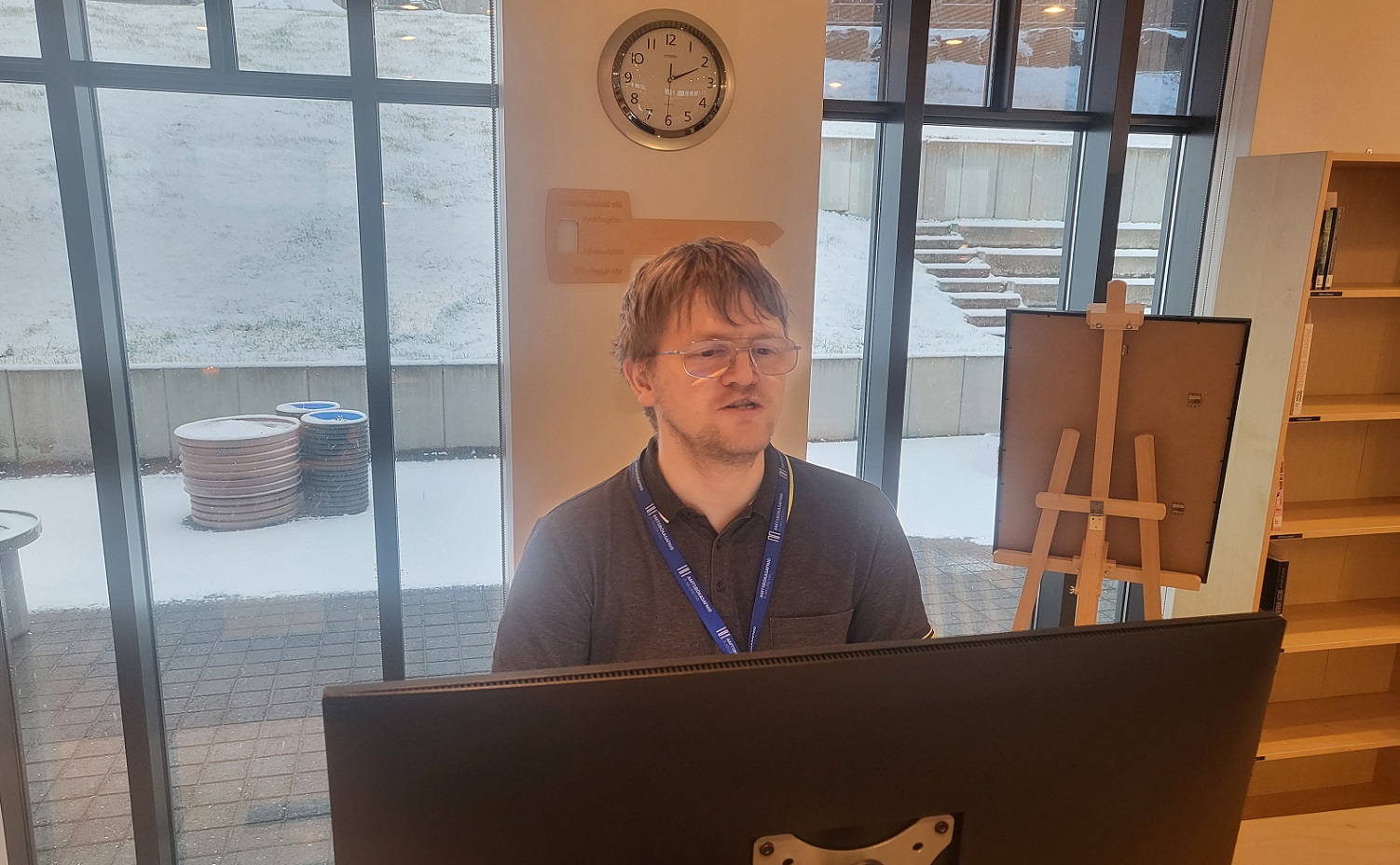 Picture of the employee Sigurður behind the circulation desk in the Municipal Library